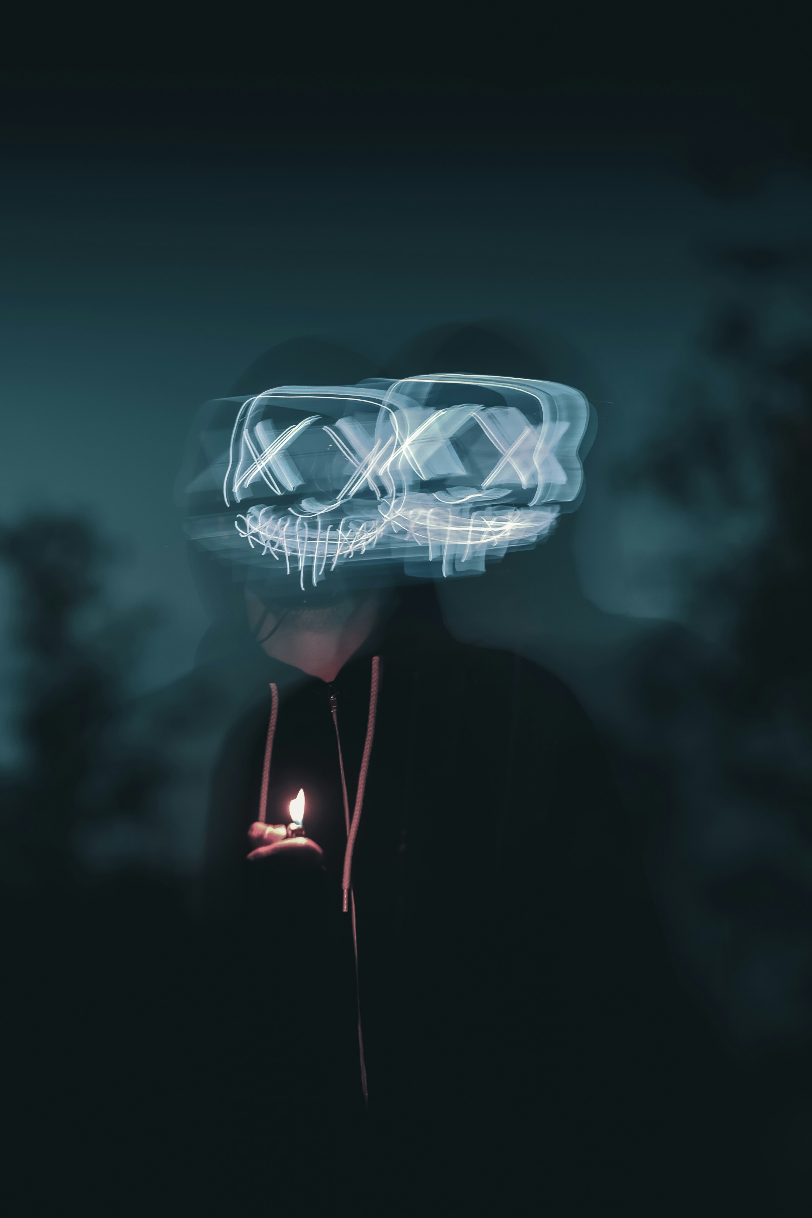 person wearing black zip-up hoodie holding lighted lighter