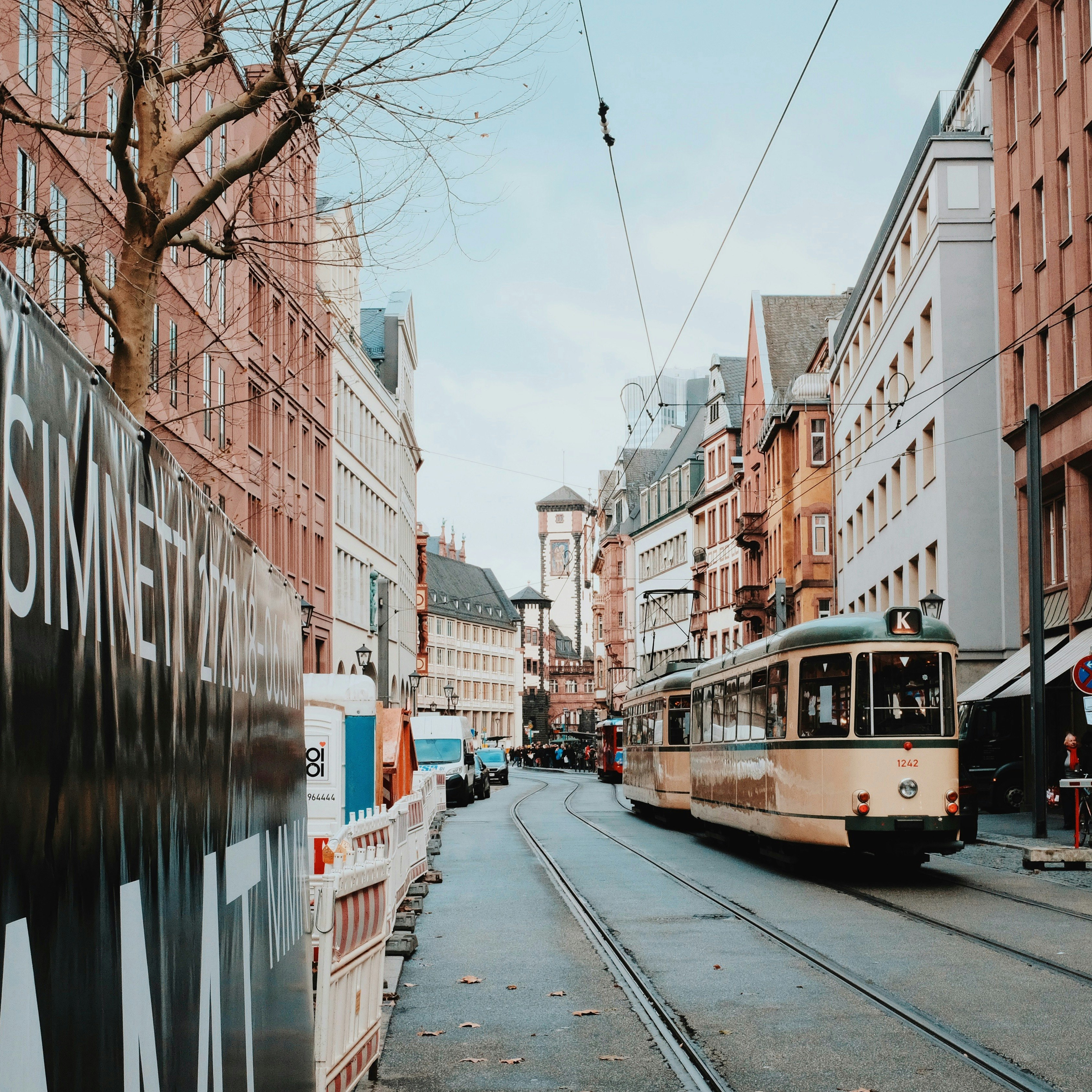 two white trains beside buildings during daytime