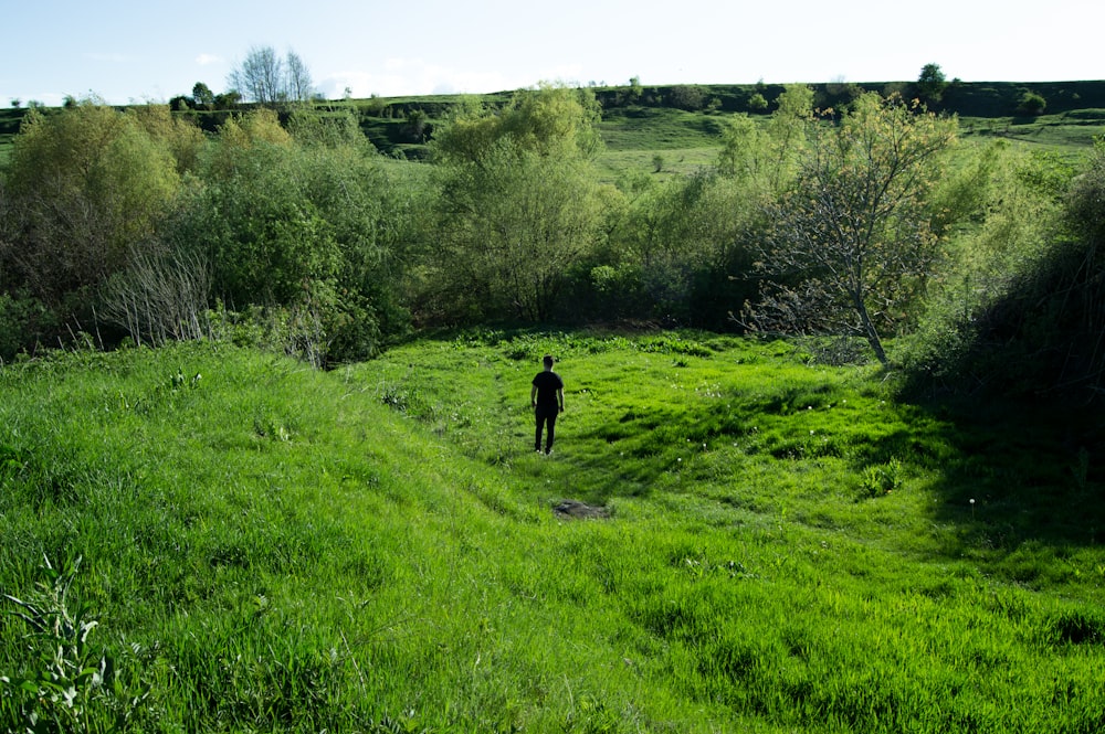 man standing on green grass field during daytime