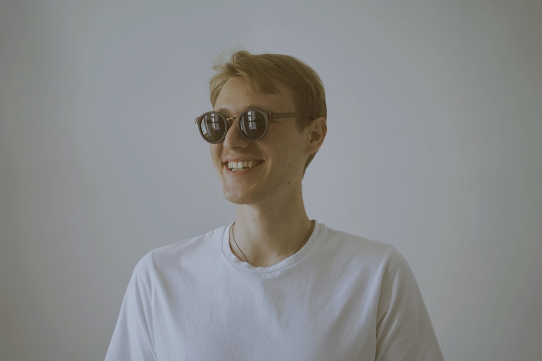 smiling man wearing white shirt and black sunglasses