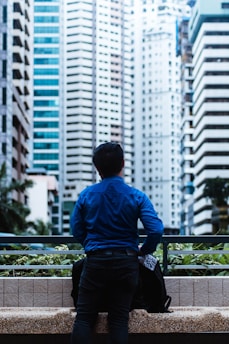 man wearing blue dress shirt looking at building