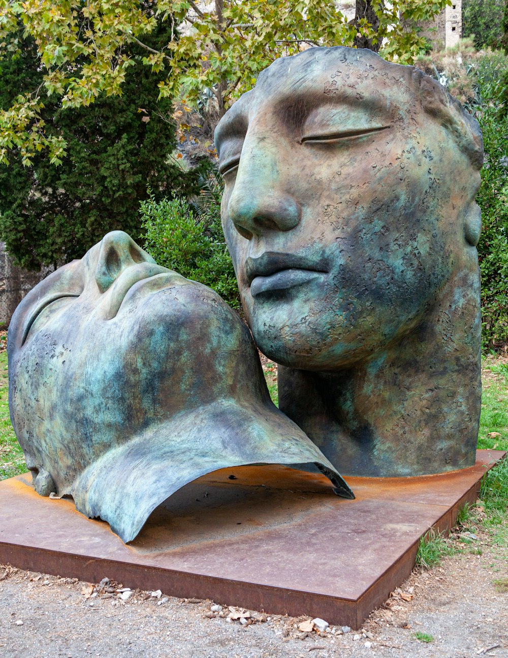 two gray statue near green trees during daytime