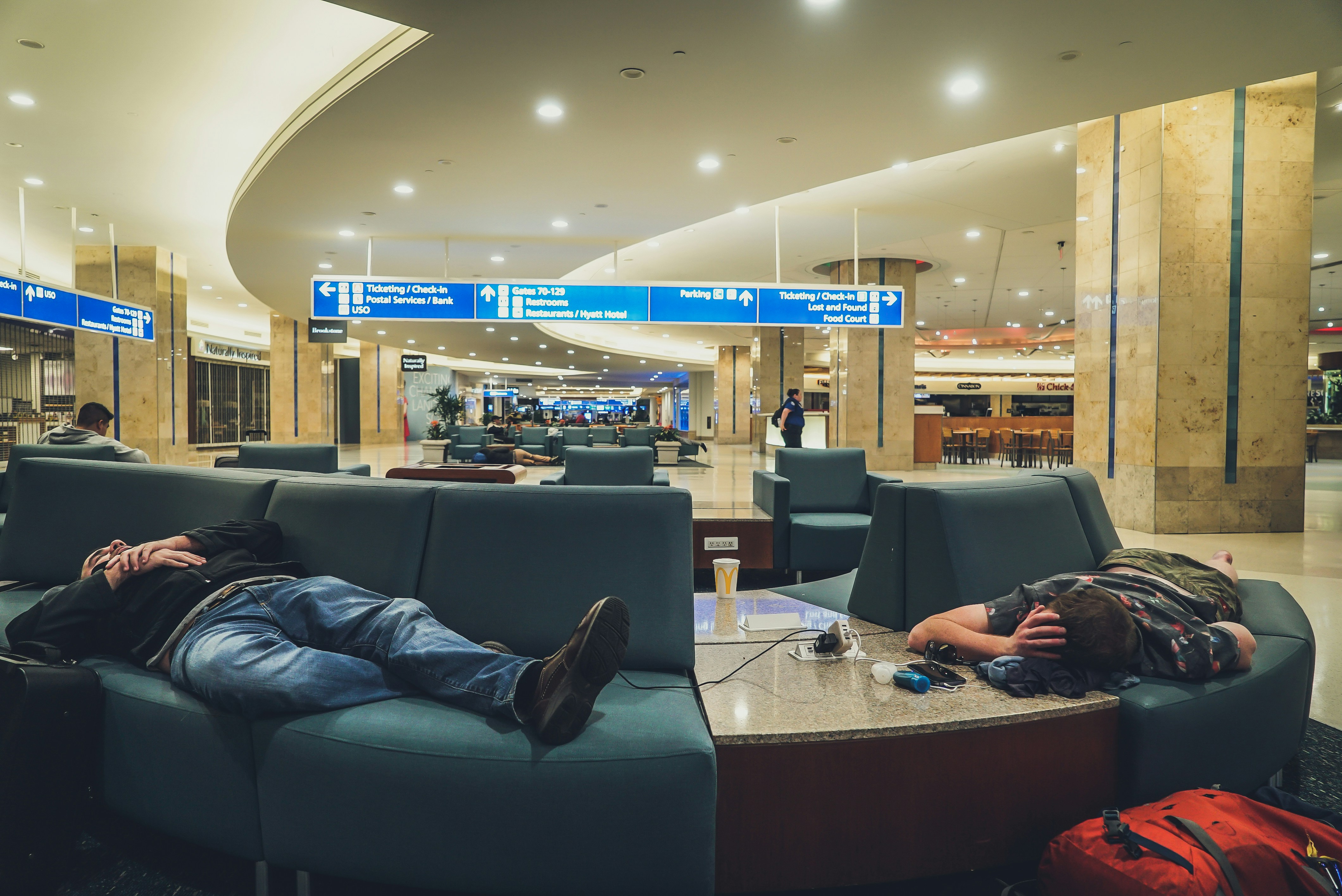 two person sleeping on blue leather sofa inside concrete building