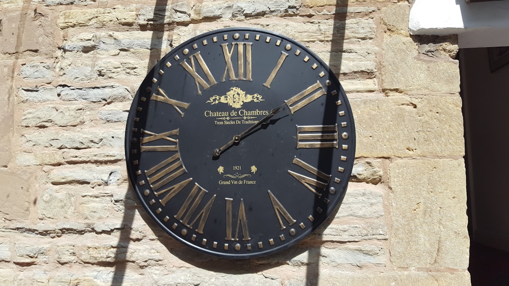 round black and brown analog wall clock displaying 2:10