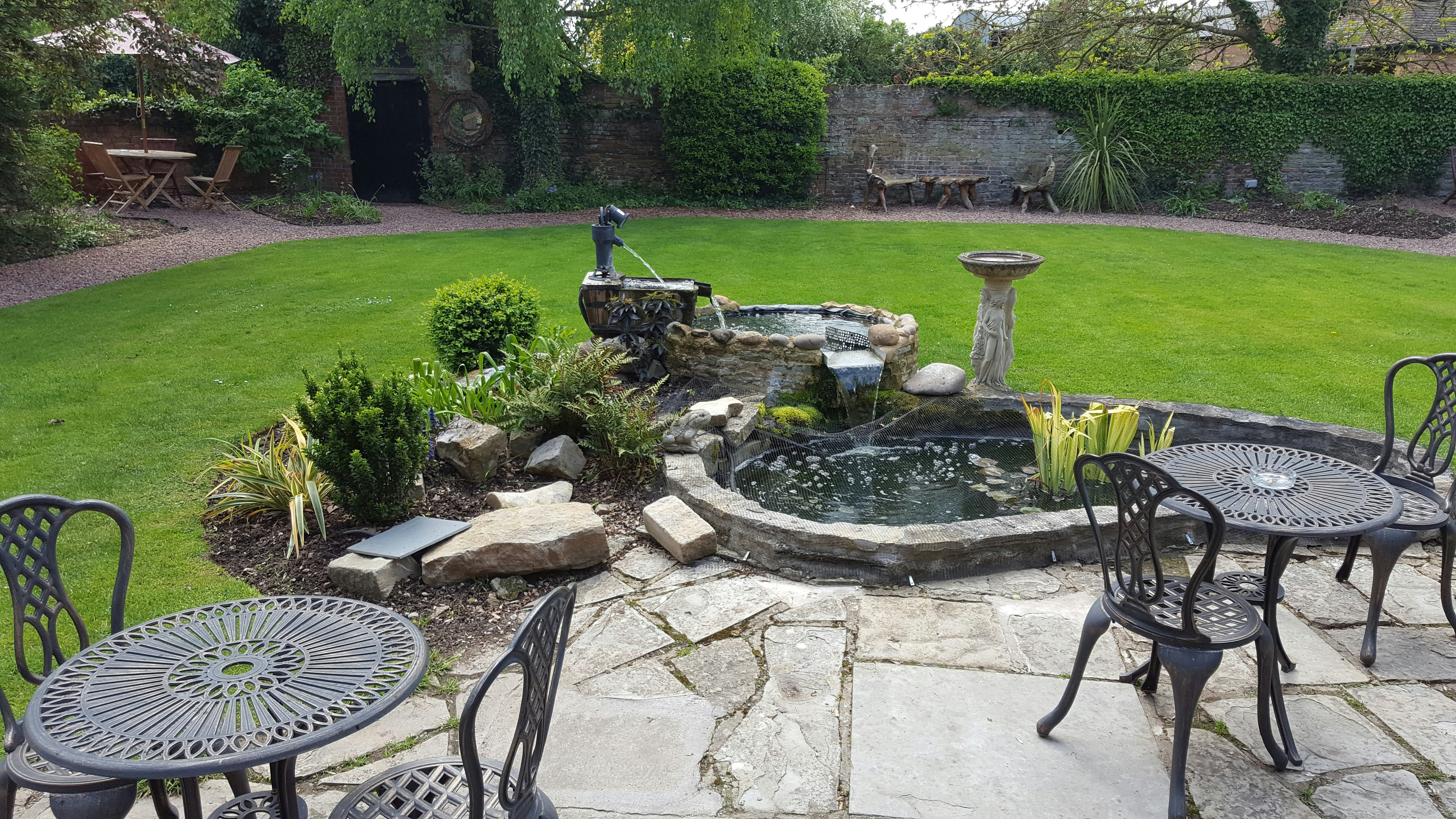 Custom backyard flagstone patio water feature with waterfall and pond installed in Galveston, TX