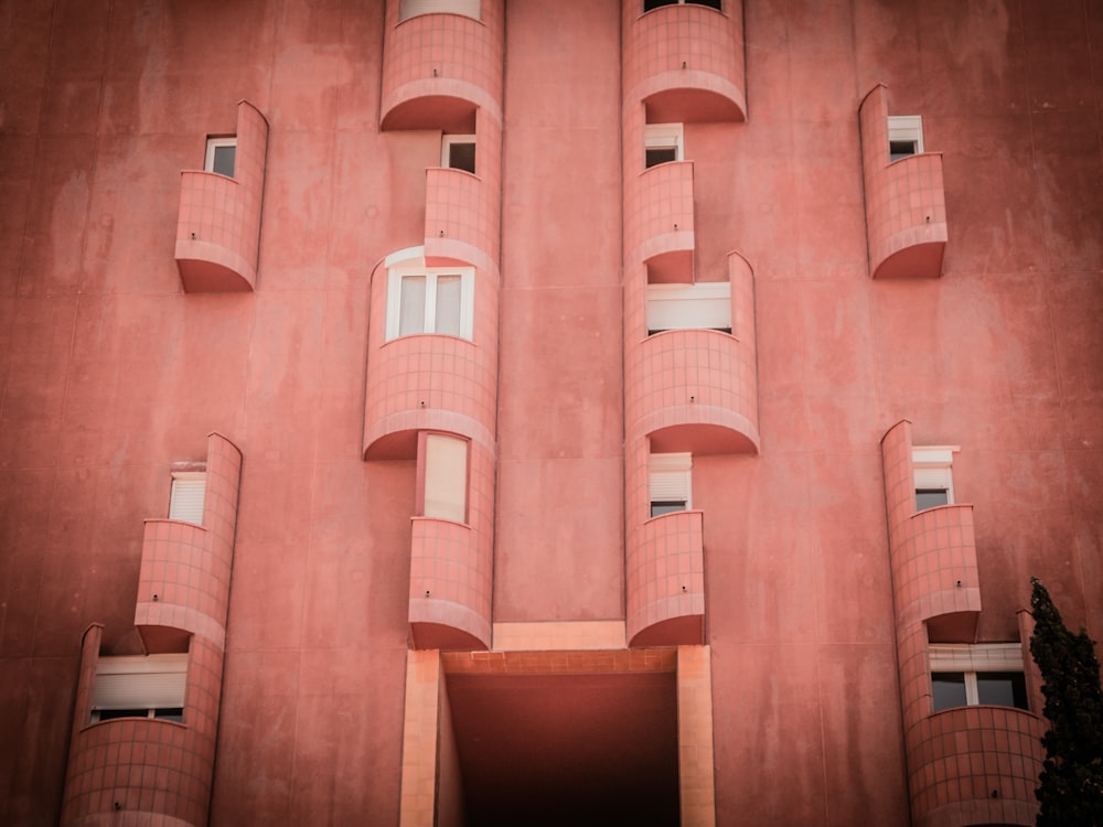 pink concrete building with balconies and windows