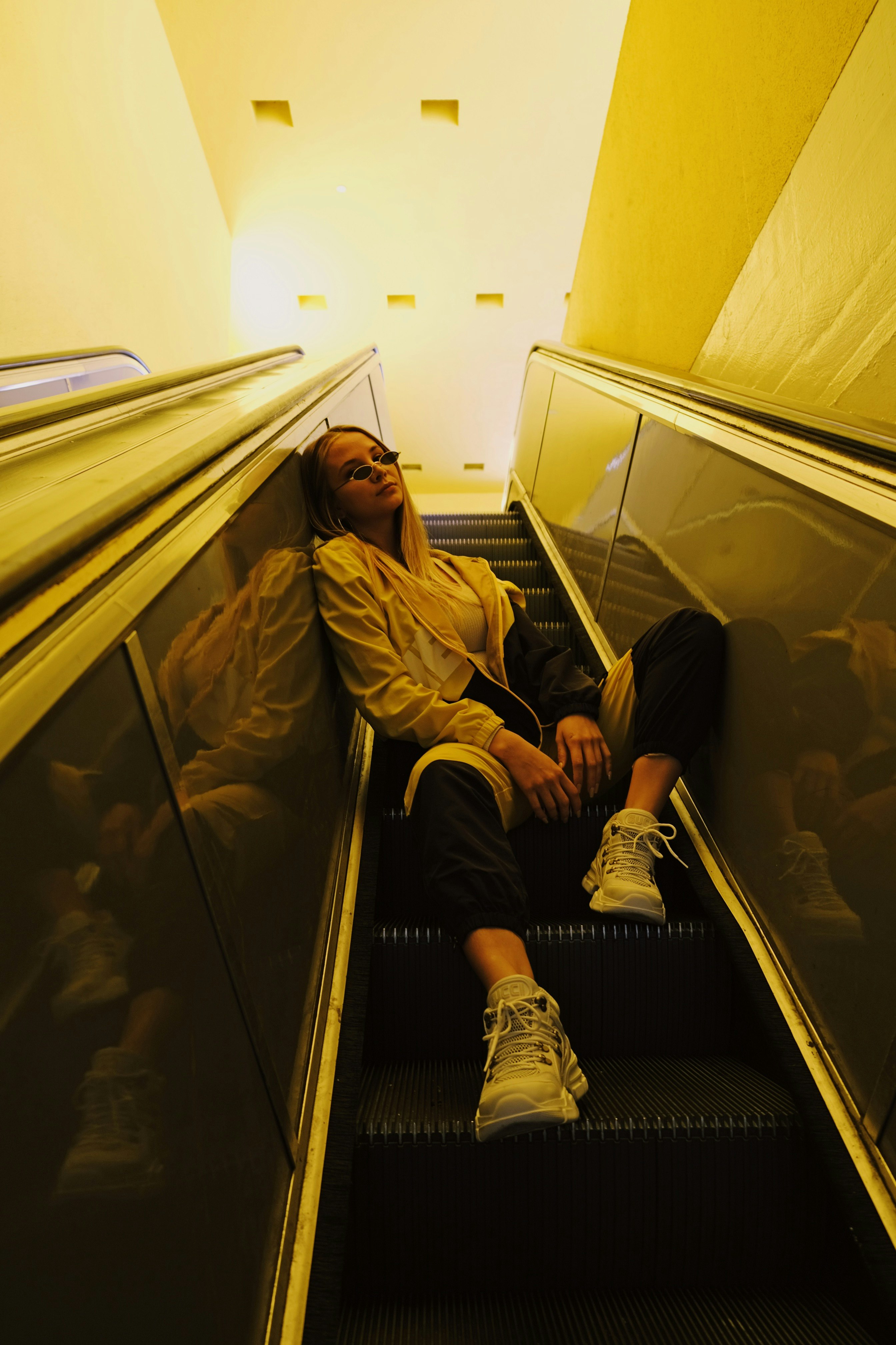 woman sitting on escalator