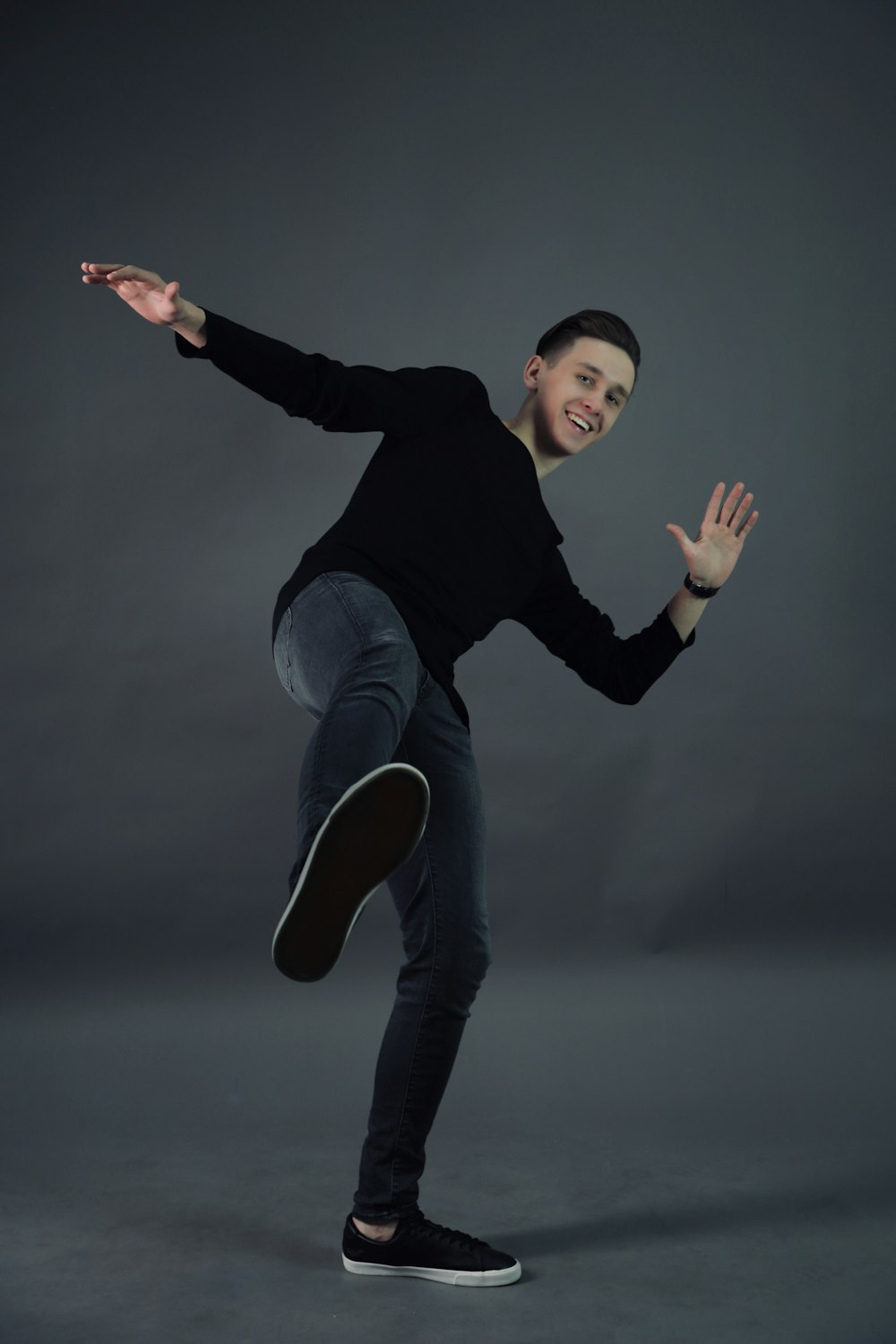 man wearing black crew-neck long-sleeved shirt and black denim jeans