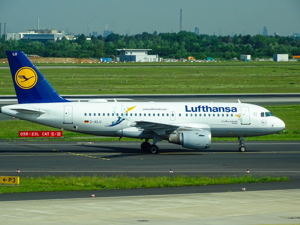 selective focus photography of white and blue Lufthansa airplane