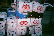 Stacked product boxes labeled with diverse brand logos ready for shipment.