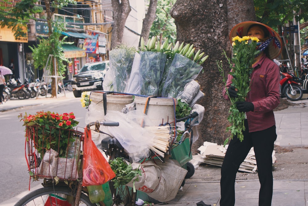 woman holding flowers near biike
