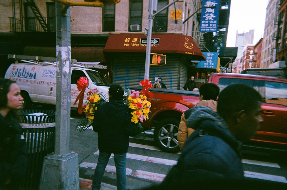 person holding flowers near pedestrian