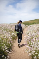 woman walking between flower fields