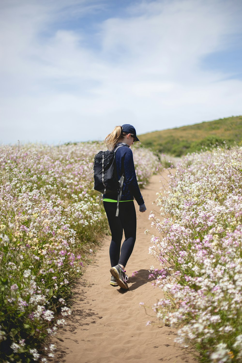 Mujer caminando entre campos de flores
