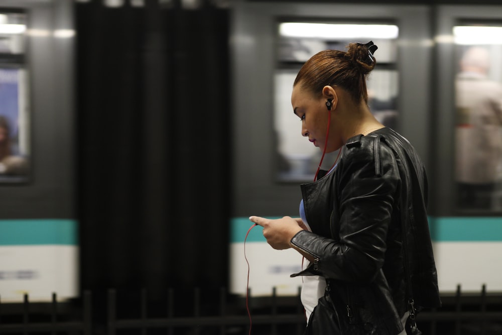 woman using phone near train