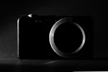 Close-up of a rigid endoscope camera head with diaphragm, softly lit on a dark background