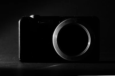 Close-up of a rigid endoscope camera head with diaphragm, softly lit on a dark background