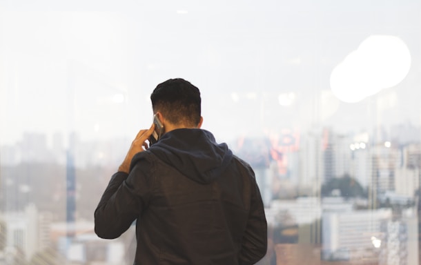A friendly call center agent in Egypt speaking on a headset with a city skyline in the background.