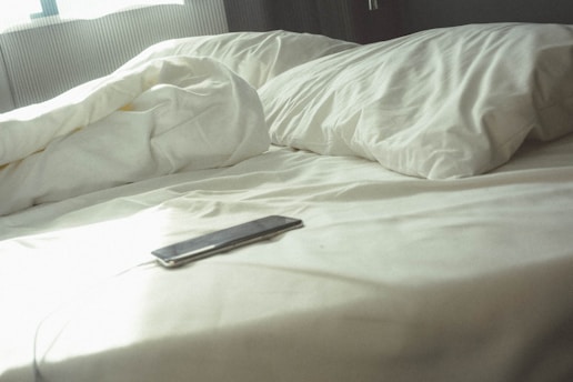 black Android smartphone on bed