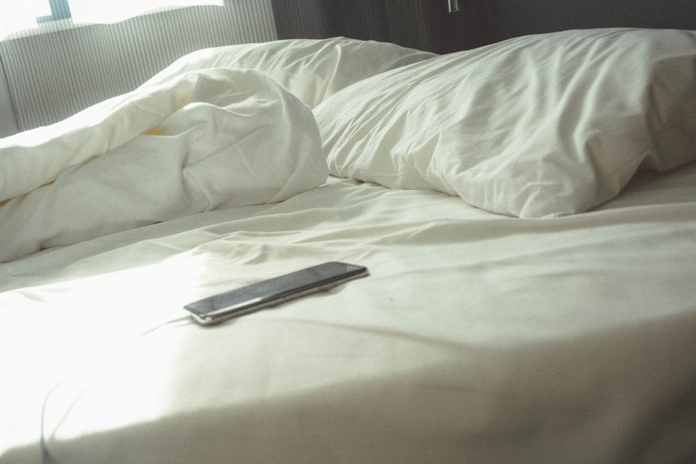 black Android smartphone on bed
