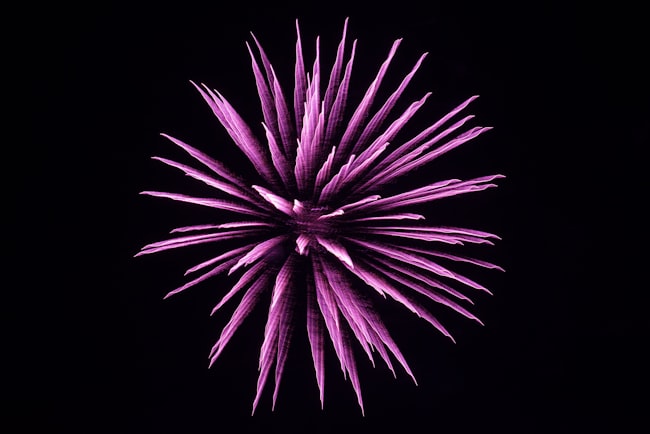 Imagem abstrata com o fundo na cor preto e no centro a simulação de uma explosão na cor lilás