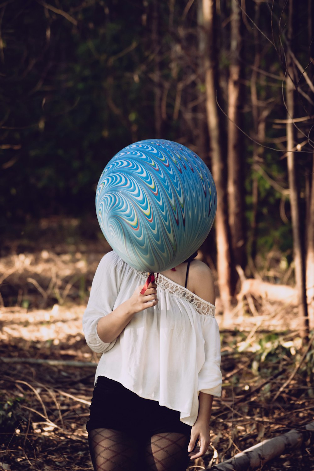 woman holding blue balloon