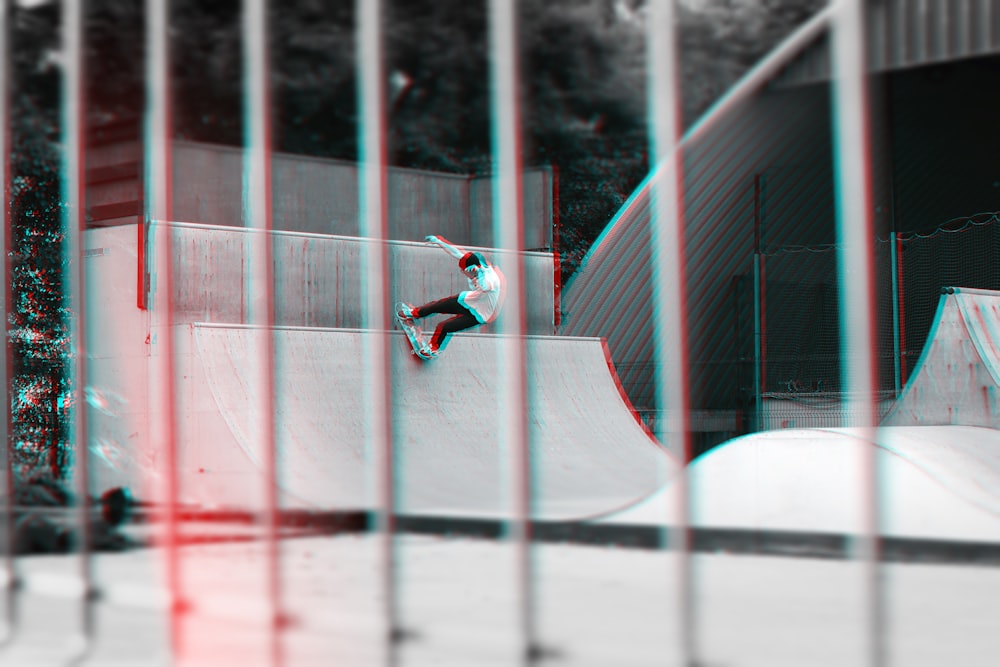 homme montant sur planche à roulettes faisant cascade gayscale photographie