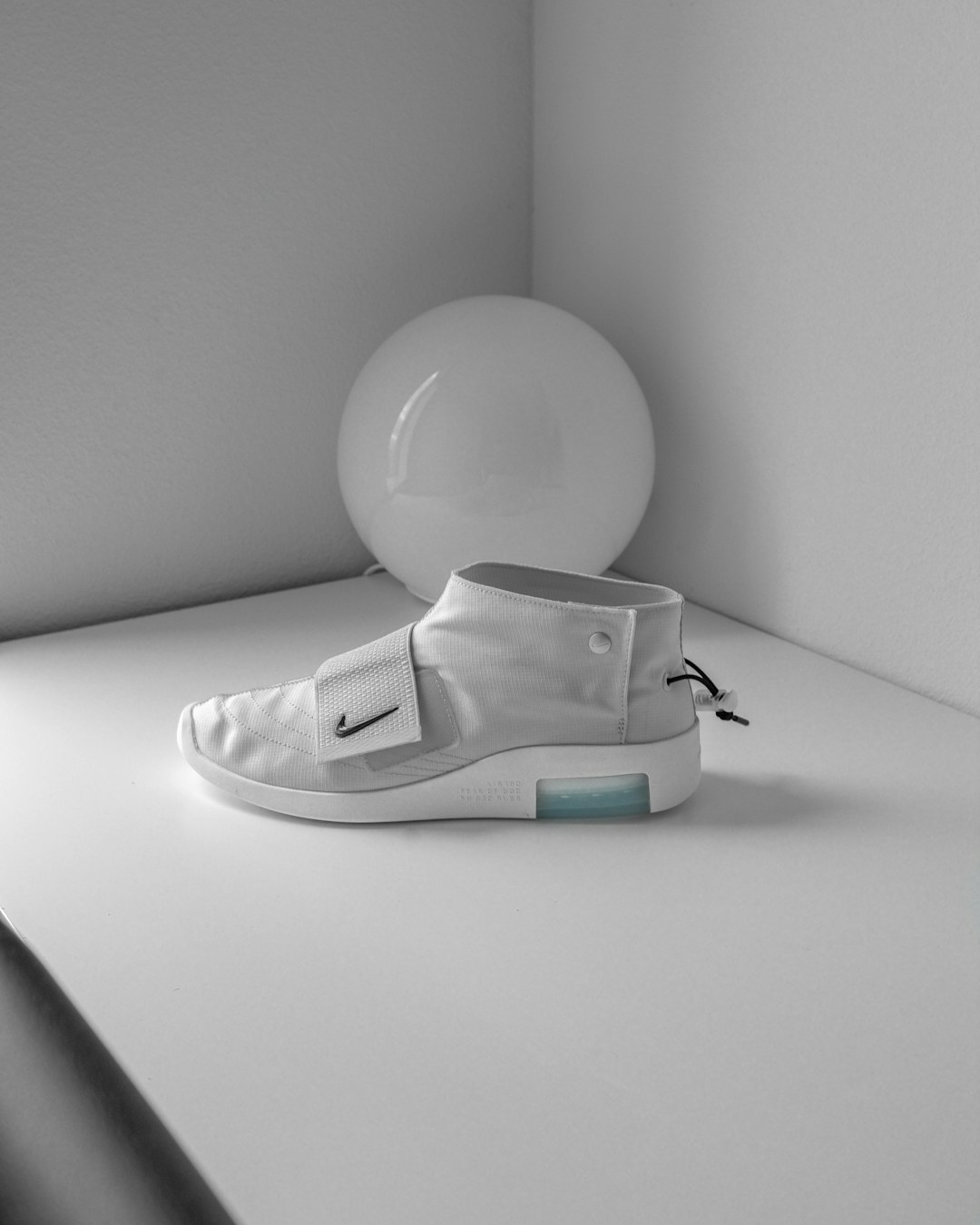 gray Nike mid-high sneaker beside white ball