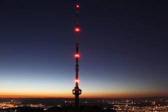 city with high-rise buildings viewing tower at night time
