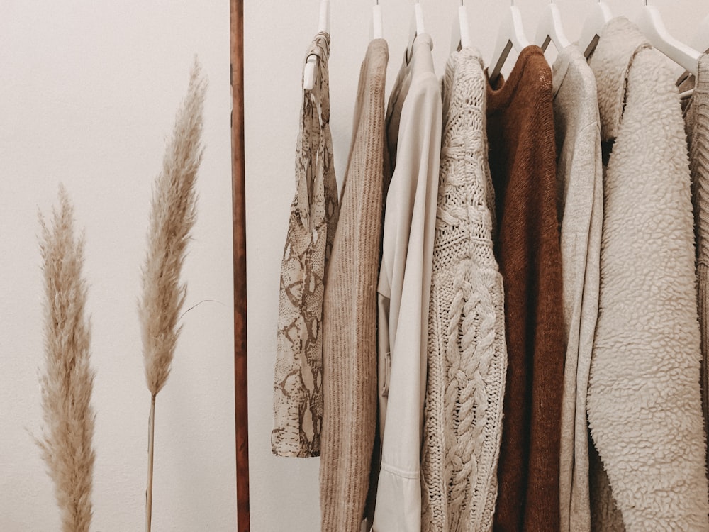 A restrained rail of cream, camel, and black garments in a quiet boutique