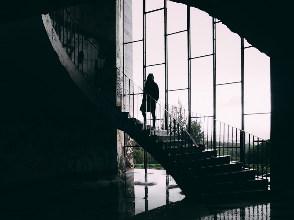 grayscale photography of woman on stair