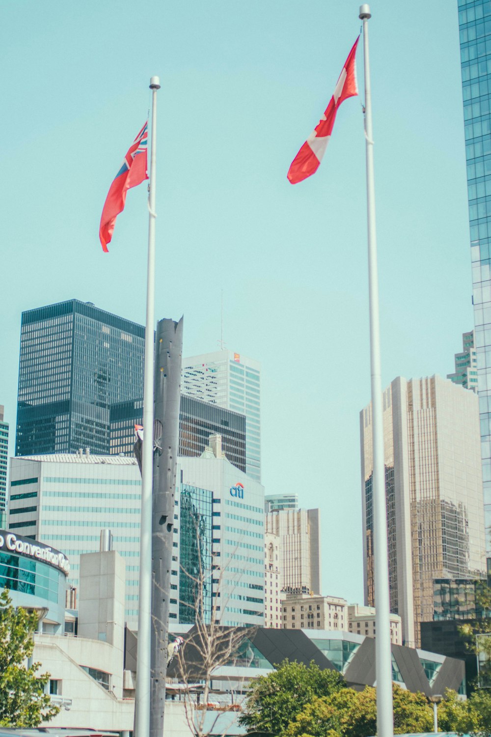 Canada flag waving on sky near high-rise buildings