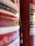 A close-up view of a red fire extinguisher with partially visible labels, hose, and some text in a foreign language. The background is slightly out of focus, emphasizing the fire extinguisher's details.