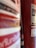 A close-up view of a red fire extinguisher with partially visible labels, hose, and some text in a foreign language. The background is slightly out of focus, emphasizing the fire extinguisher's details.
