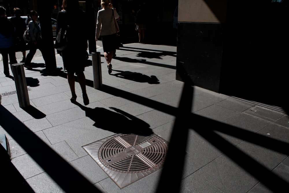 a group of people walking down a sidewalk