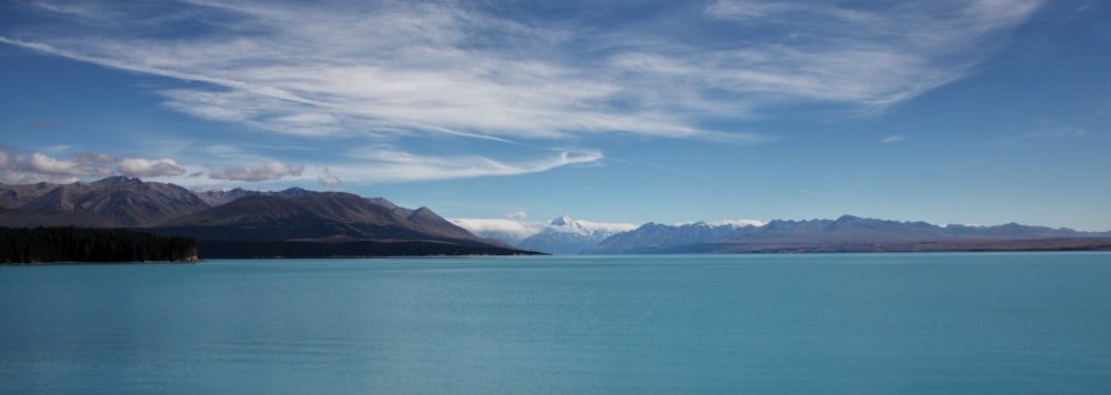 landscape photo of body of water and mountain ranges