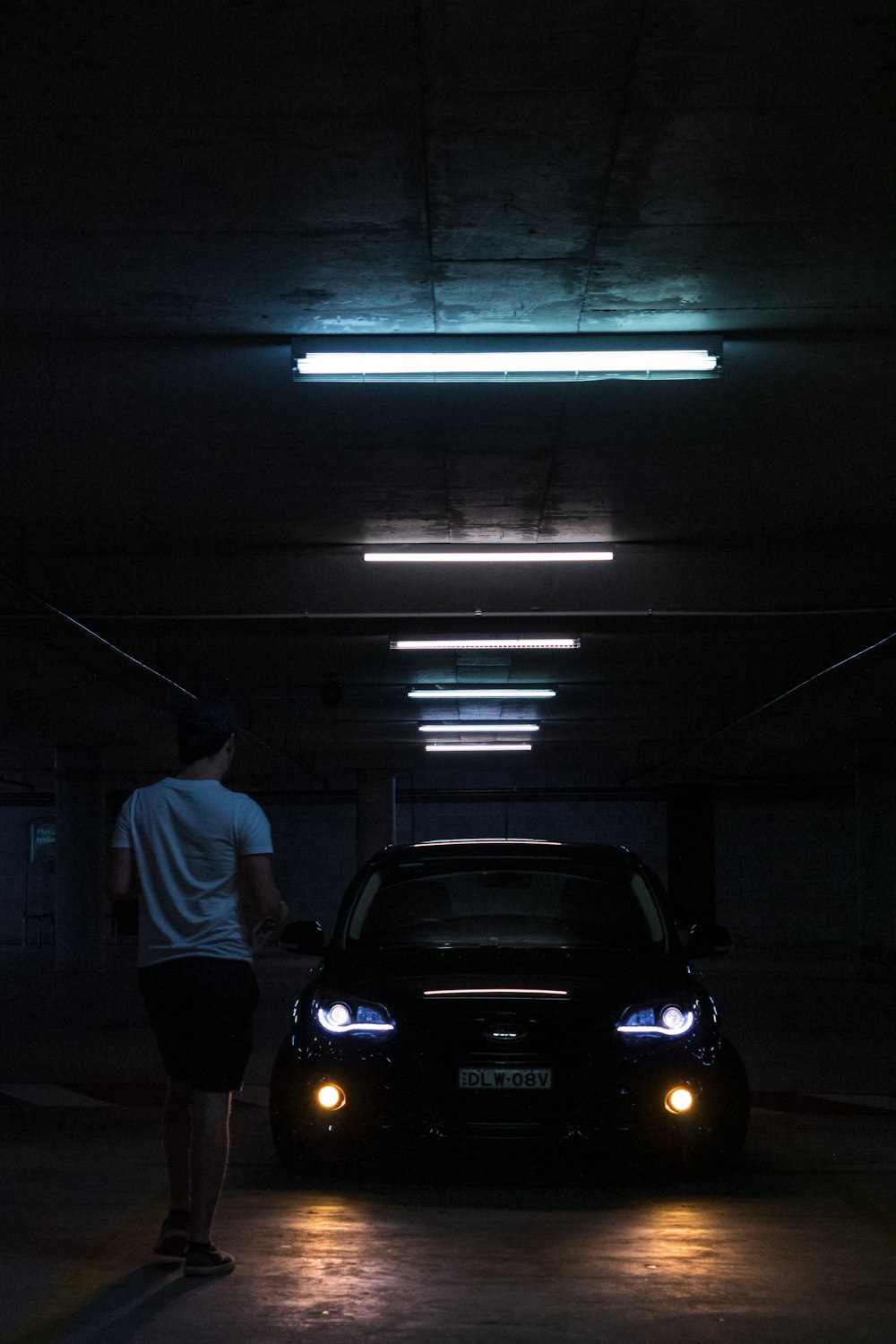 man standing near black car