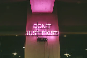 purple Don't Just Exist neon signage turned-on
