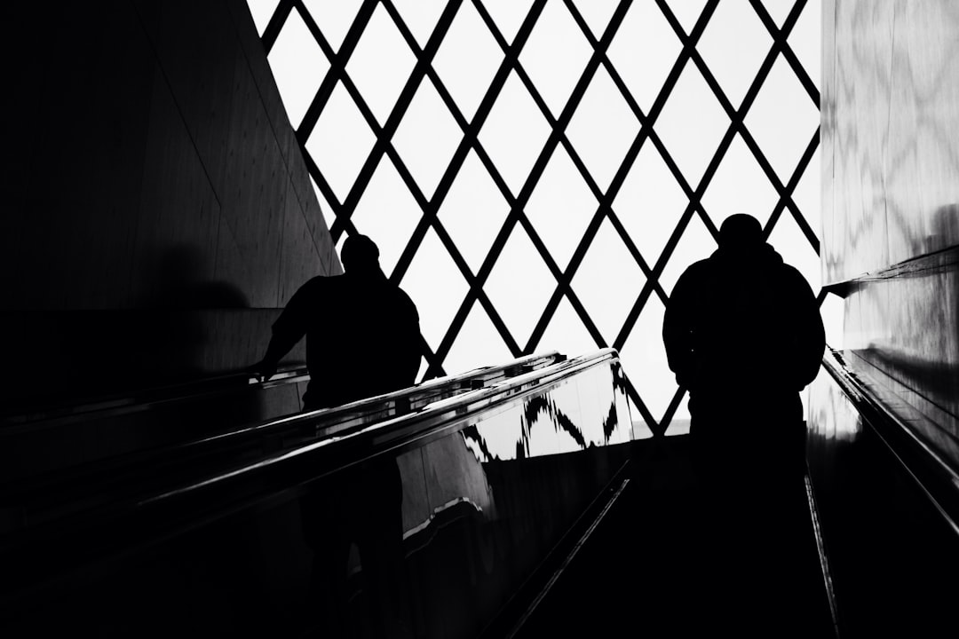 man standing on escalator,