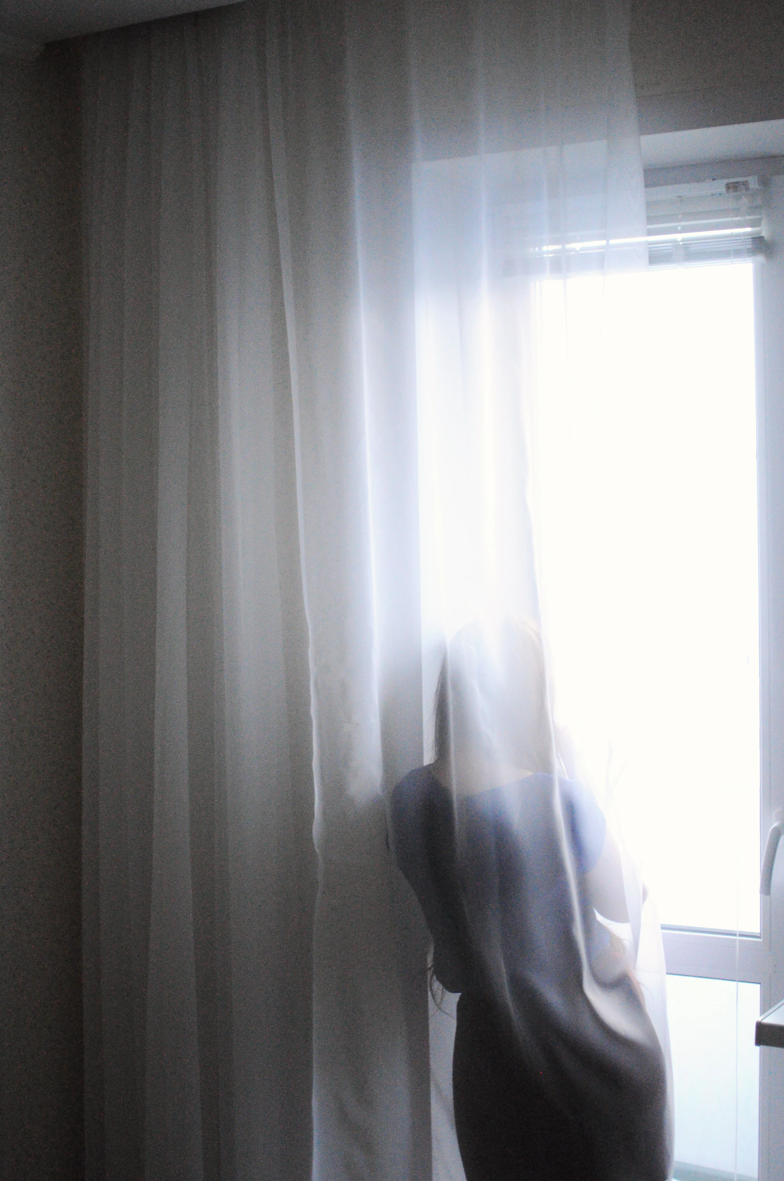 Frau steht ruhig an einem Fenster als Symbol für bewusst wahrgenommene Atmung nach dem Rauchstopp