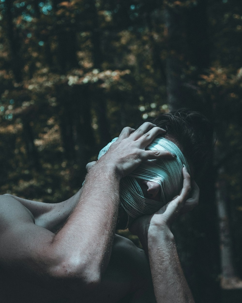 a shirtless man holding a ball in front of his face