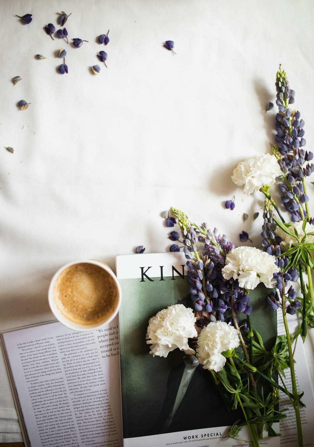 cup of coffee near white-petaled flower