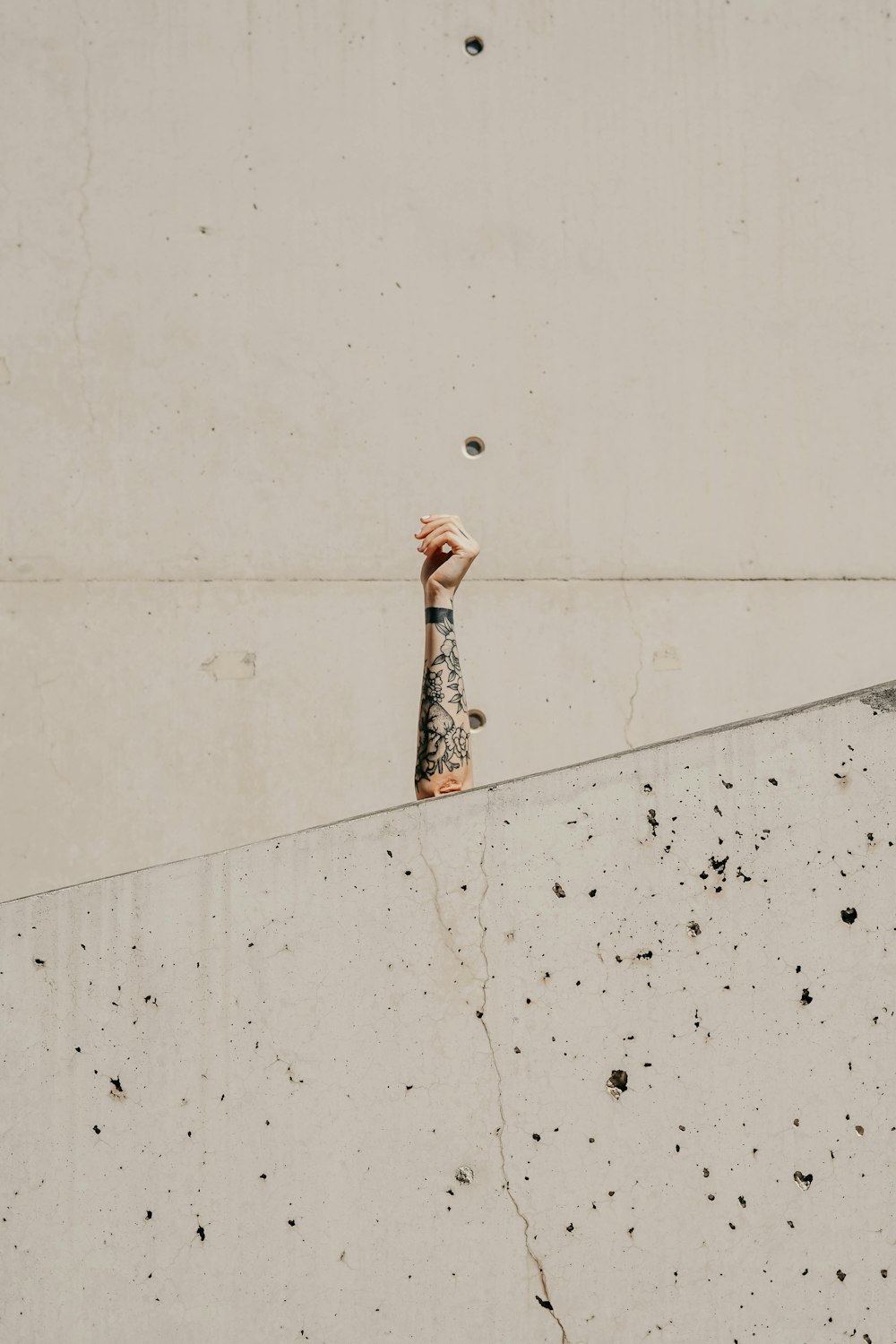 Die Hand der Person auf der Vorderseite der grauen Wand