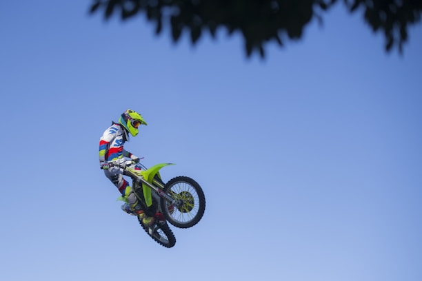 A dynamic motocross rider mid-jump against a bright Florida sky.