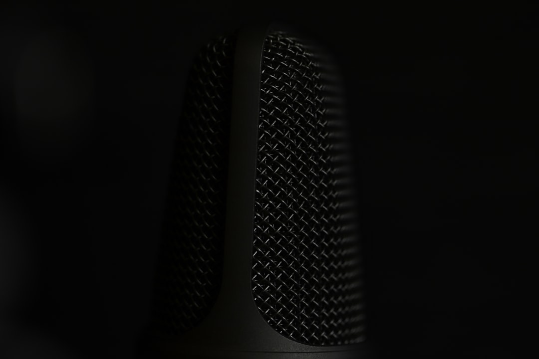a close up of a microphone in the dark, Closeup of a microphone isolated on black.