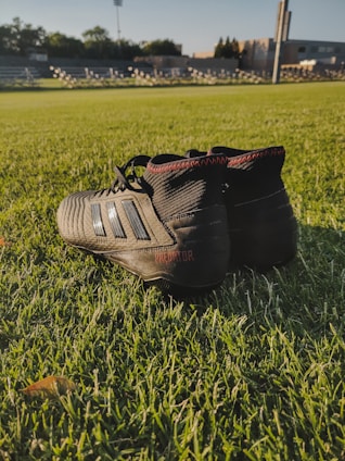 An assortment of colorful football cleats displayed on a sports field.
