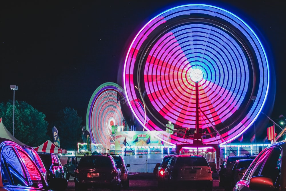 a carnival with a ferris wheel at night
