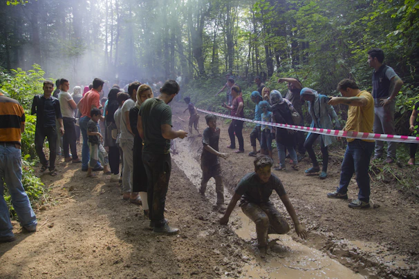 A group of toddlers exploring a shallow pond during an outdoor nature walk