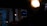 A dimly lit indoor environment with an illuminated 'GRAPH' sign in the background. Warm overhead lights create a cozy atmosphere, with a focus on the contrast between darkness and the bright sign.