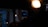 A dimly lit indoor environment with an illuminated 'GRAPH' sign in the background. Warm overhead lights create a cozy atmosphere, with a focus on the contrast between darkness and the bright sign.